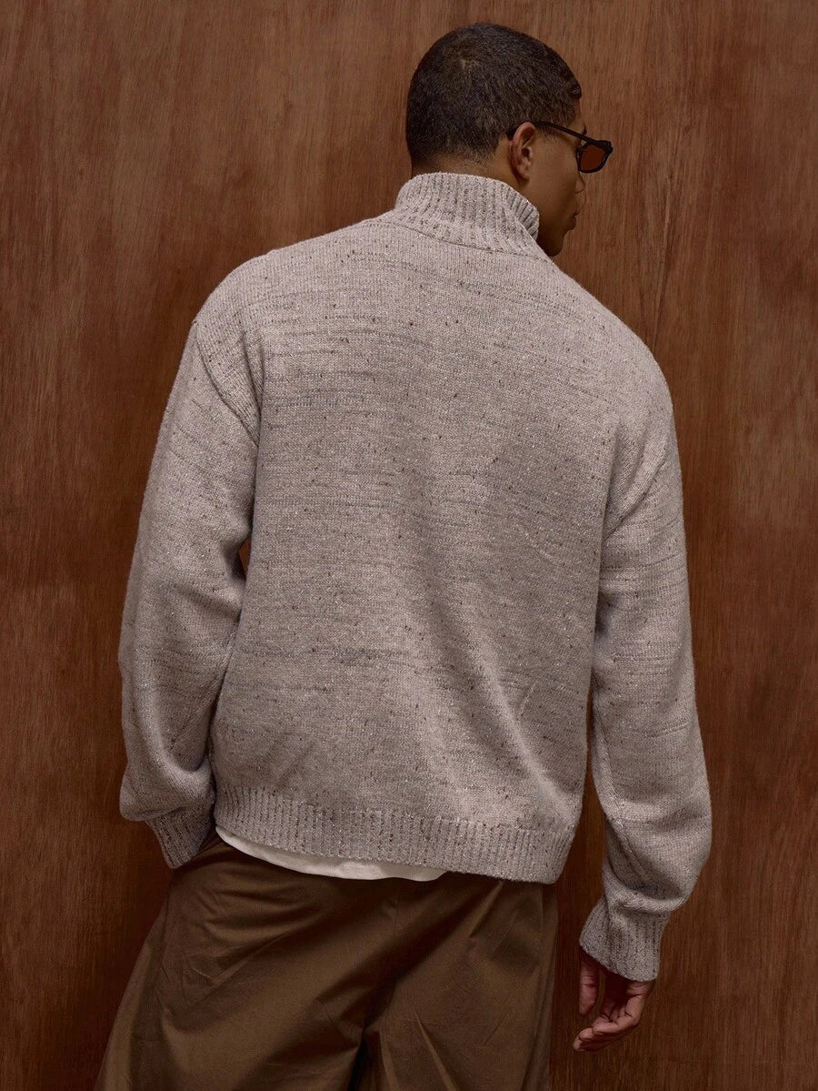 Zippered knit sweater with a stand‑up collar and a patterned design.